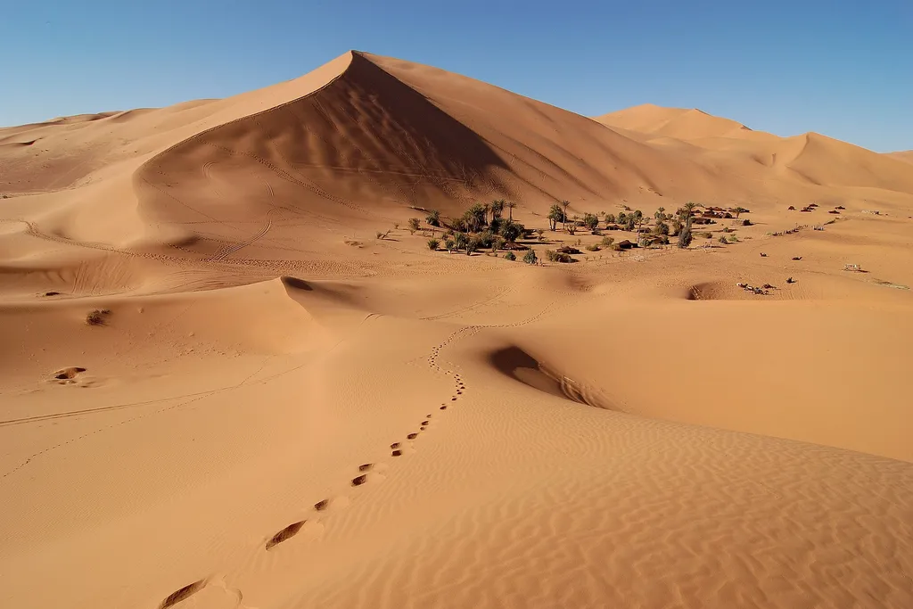 A small village at the edge of the orange Erg Chebbi sand dunes near Merzouga in the Moroccan Sahara