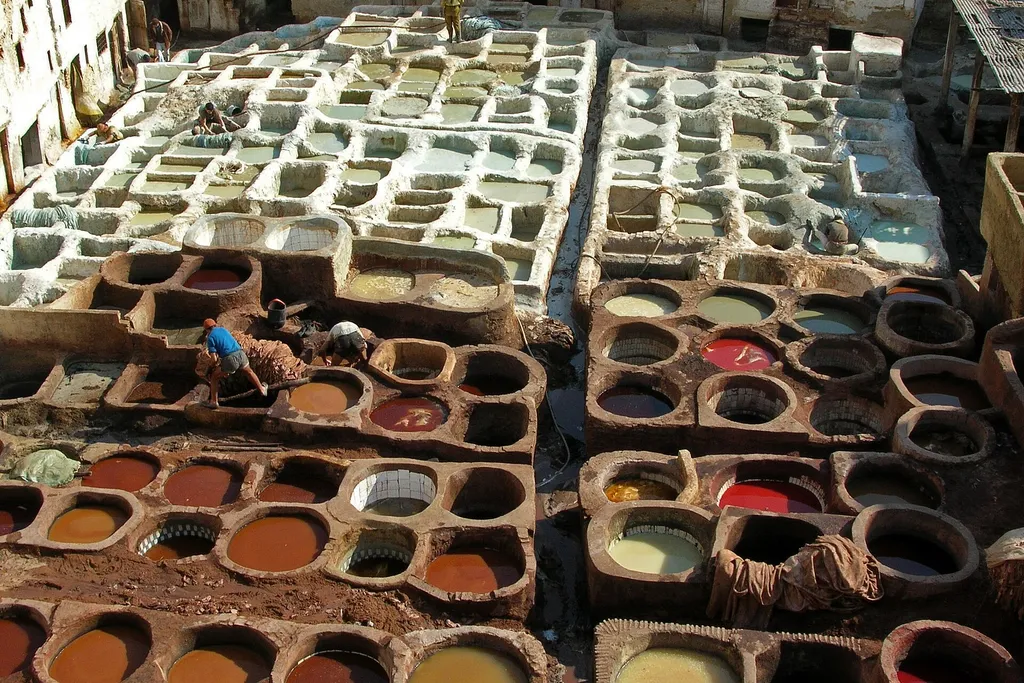 Workers treating leather in the round stone vats of the Chouara Tannery in Fes el Bali, Morocco