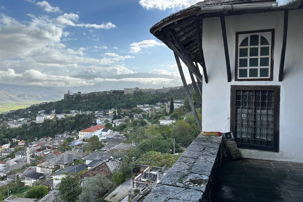 View over the stone-roofed old town of Gjirokaster from the Zekate House, with the castle hill in the distance