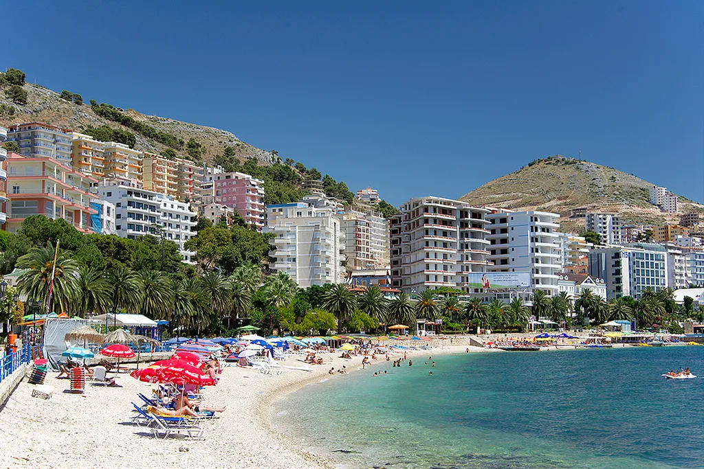 Sarande city beach and palm-lined promenade curving around the bay on the Albanian Riviera