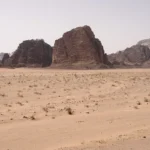 Sandstone mountains rising from the desert floor in Wadi Rum, Jordan
