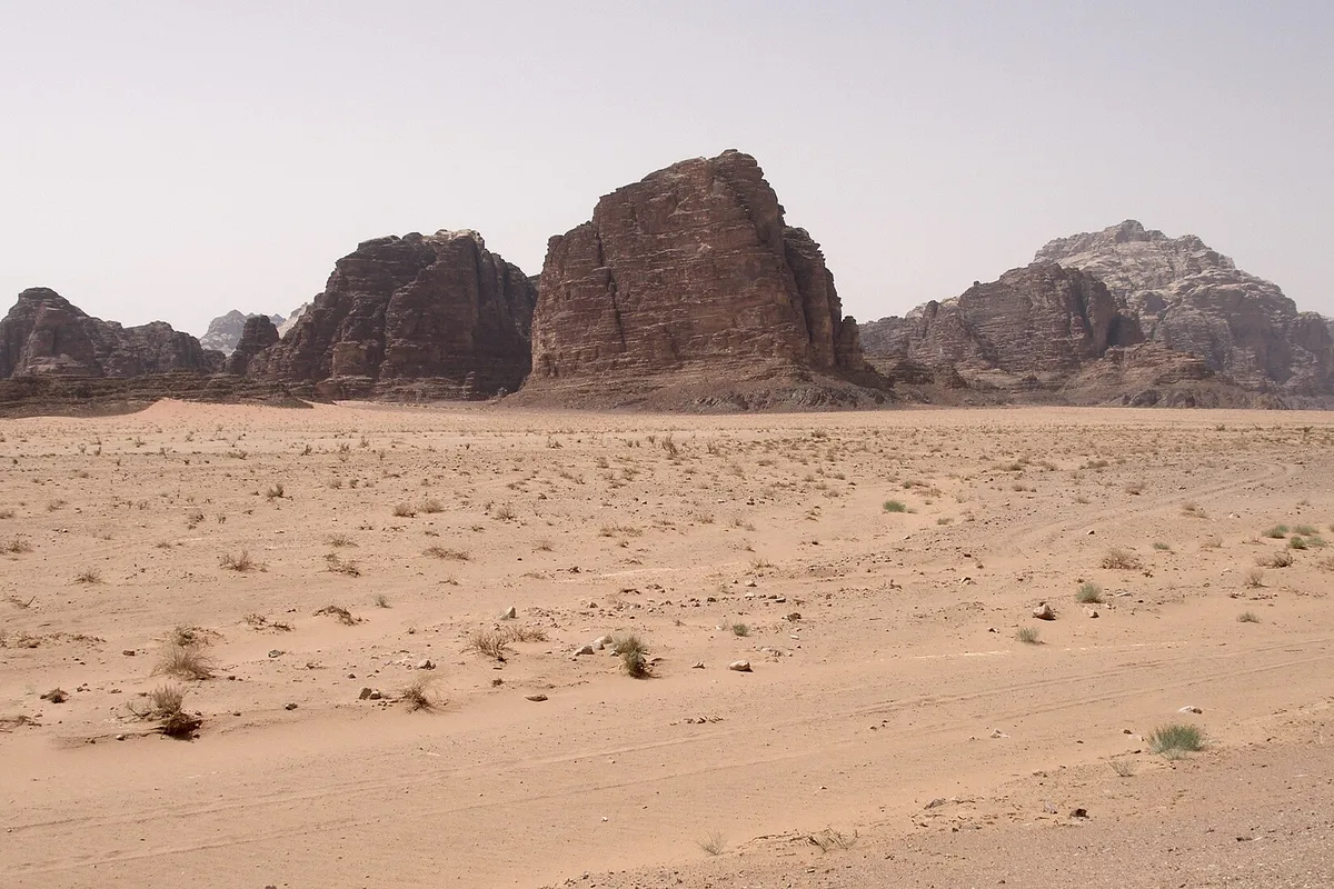 Sandstone mountains rising from the desert floor in Wadi Rum, Jordan